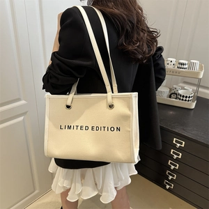 Large beige canvas tote bag with Limited Edition print carried by a model in interior
