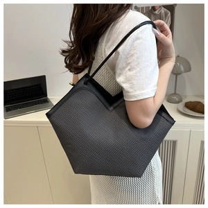 Detail of dark grey woven tote bag with V-cut opening and slim straps for daily commute