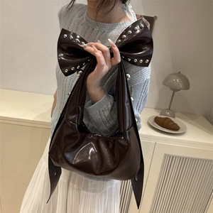 Sac bandoulière marron foncé avec grand nœud à rivets et texture plissée vintage chic