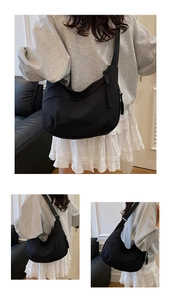 Detail of black nylon hobo bag with adjustable strap and woven zipper pullers