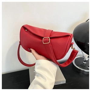 Close-up of red lychee grain leather handbag with decorative gold square buckle detail