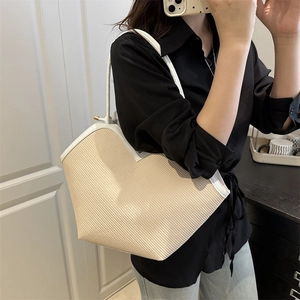 Summer woven tote bag with white leather straps in a stylish mirror selfie view