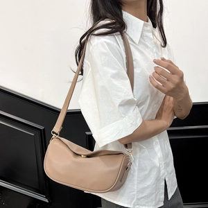 Minimalist beige half-moon crossbody bag with golden clasp and soft pebbled texture