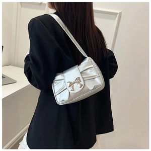 Détail du sac à bandoulière argenté métallisé avec plis et décor de nœud argenté