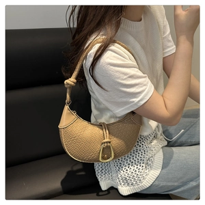 Detail of hobo bag with crocodile embossed leather and gold horseshoe metal buckle