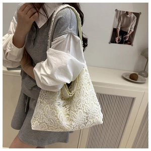 Détail de la dentelle florale blanche délicate et des motifs ajourés sur le sac fourre-tout