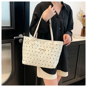 Grand sac cabas crème avec motifs nœuds noirs et boucle papillon dorée élégante