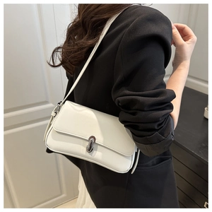 Side view of white faux leather underarm bag with silver buckle on a model