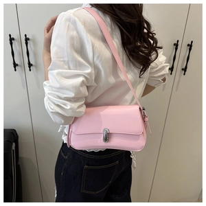 Detail of pink faux leather shoulder bag featuring a silver metal twist lock closure