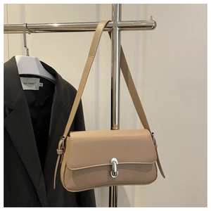 Detail of minimalist beige faux leather shoulder bag with silver oval metal clasp buckle