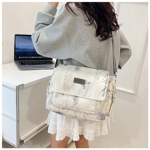 Detail of white nylon messenger bag with Chinese calligraphy patterns and adjustable strap