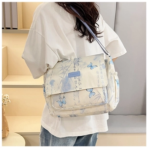 Detail view of large capacity canvas bag with butterfly print and blue shoulder strap