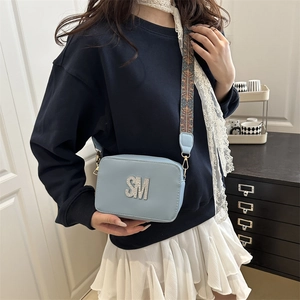 Light blue faux leather square bag with rhinestone SM logo and wide patterned strap