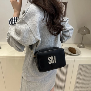 Chic black crossbody camera bag with silver rhinestone SM logo and adjustable wide strap