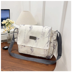 Detail of white butterfly print crossbody bag featuring a wide nylon strap and side pocket