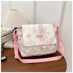 Detail of a beige canvas bag with pink butterfly prints and a fashion leather label