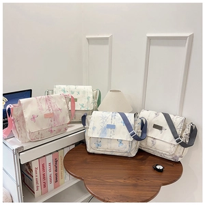 Detail of four colorful patterned canvas messenger bags with adjustable straps and Chinese prints
