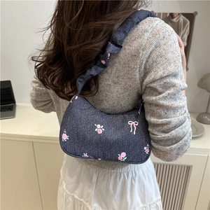 Blue denim underarm bag with pink floral embroidery and ruffled cloud strap