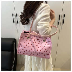 Side view of large pink cherry print tote bag on shoulder with long straps