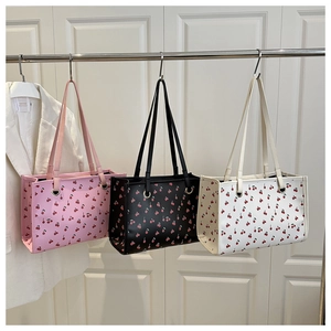 Detailed display of tote bags in pink, black, and white with cherry print patterns