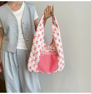 Détail du sac cabas floral avec imprimé nœuds rouges et poche à carreaux