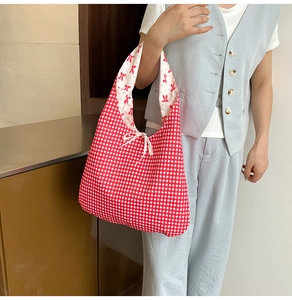 Détail d'un sac cabas en tissu vichy rouge avec doublure à nœuds et lien de serrage