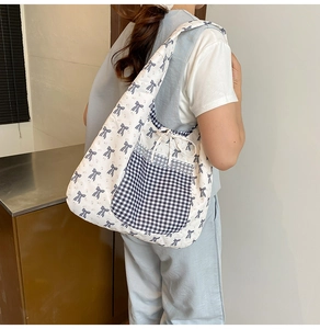 Détail du sac cabas en toile avec motifs nœuds bleus et une poche avant à carreaux