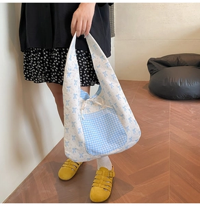Détail du sac cabas à nœud bleu avec poche vichy et bordure en dentelle sur toile