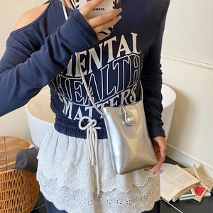 Mini silver metallic phone crossbody bag with large pearl clasp on fashion model