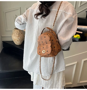 Gros plan d'un mini sac à dos marron avec motifs d'ours et chaînes métalliques