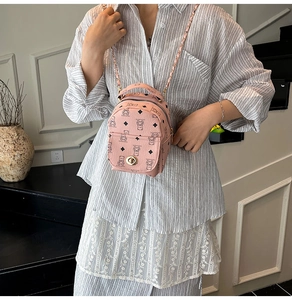 Détail du mini sac à dos rose avec motif d'ours et chaîne métallique élégante