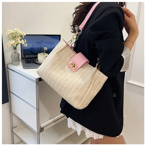 Détail du sac en paille tressée beige avec rabat en cuir rose et boucle dorée