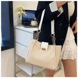 Détail du sac cabas en paille avec rabat en cuir blanc et fermoir rotatif doré