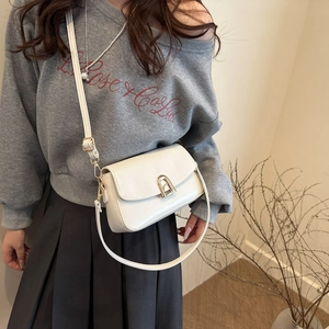 Sac bandoulière blanc minimaliste avec fermoir doré en forme d'arche sur un mannequin