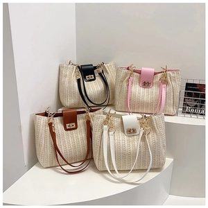 Détail de sacs fourre-tout en paille tissée avec rabats en cuir et verrous dorés rotatifs