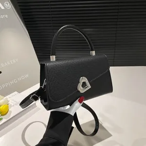Black pebbled leather crossbody bag with silver heart buckle and adjustable strap