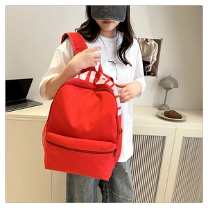 Red waterproof nylon backpack featuring a large white logo and spacious compartments
