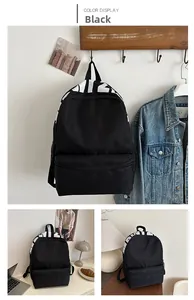 Detail of minimalist black canvas backpack with white letter print and mesh side pockets