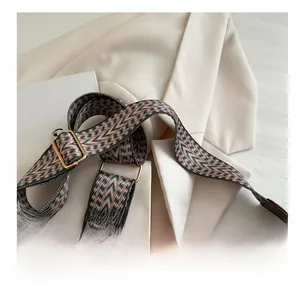 Close-up of pink and green wave pattern woven shoulder strap with gold metal hardware