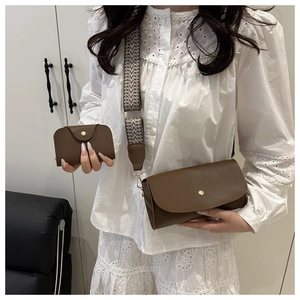 Brown stone textured tote bag with wide geometric woven shoulder strap and small pouch