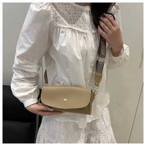Detail view of khaki crossbody bag with geometric woven strap and gold metal buckle