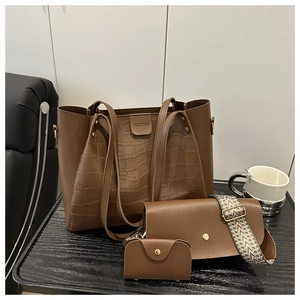 Detailed close-up of brown crocodile texture tote bag with crossbody bag set on a desk