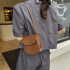 Retro brown leather saddle bag for women, crossbody style shown on model in cafe