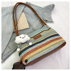 Detail of colorful striped woven bucket bag with brown leather strap and cloud charm