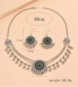 Detail view of vintage silver jewelry set with green stones and layered chains