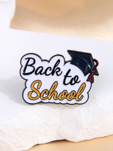 Détail d'une broche émaillée Back to School avec chapeau de diplômé sur pierre blanche