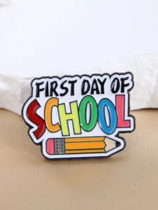 Détail du pin's émaillé First Day of School avec crayon coloré et texte gravé