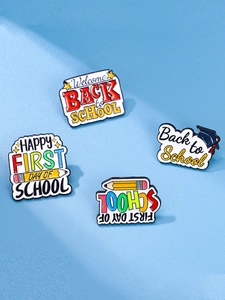 Détail de quatre épinglettes en émail colorées avec crayons et toques de diplôme