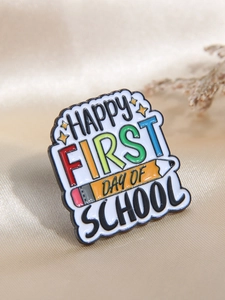 Gros plan sur la broche émaillée colorée avec texte Happy First Day of School