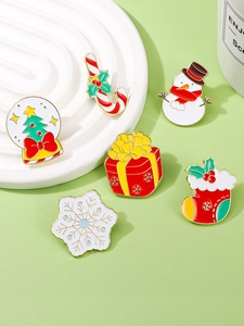 Detail of Christmas enamel pins set including snowman and tree on display tray